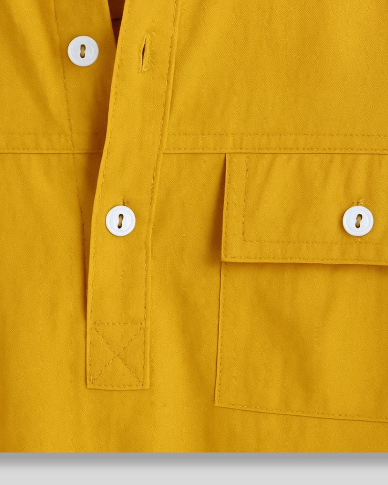 Close-up of chest pocket and placket detailing on yellow shirt