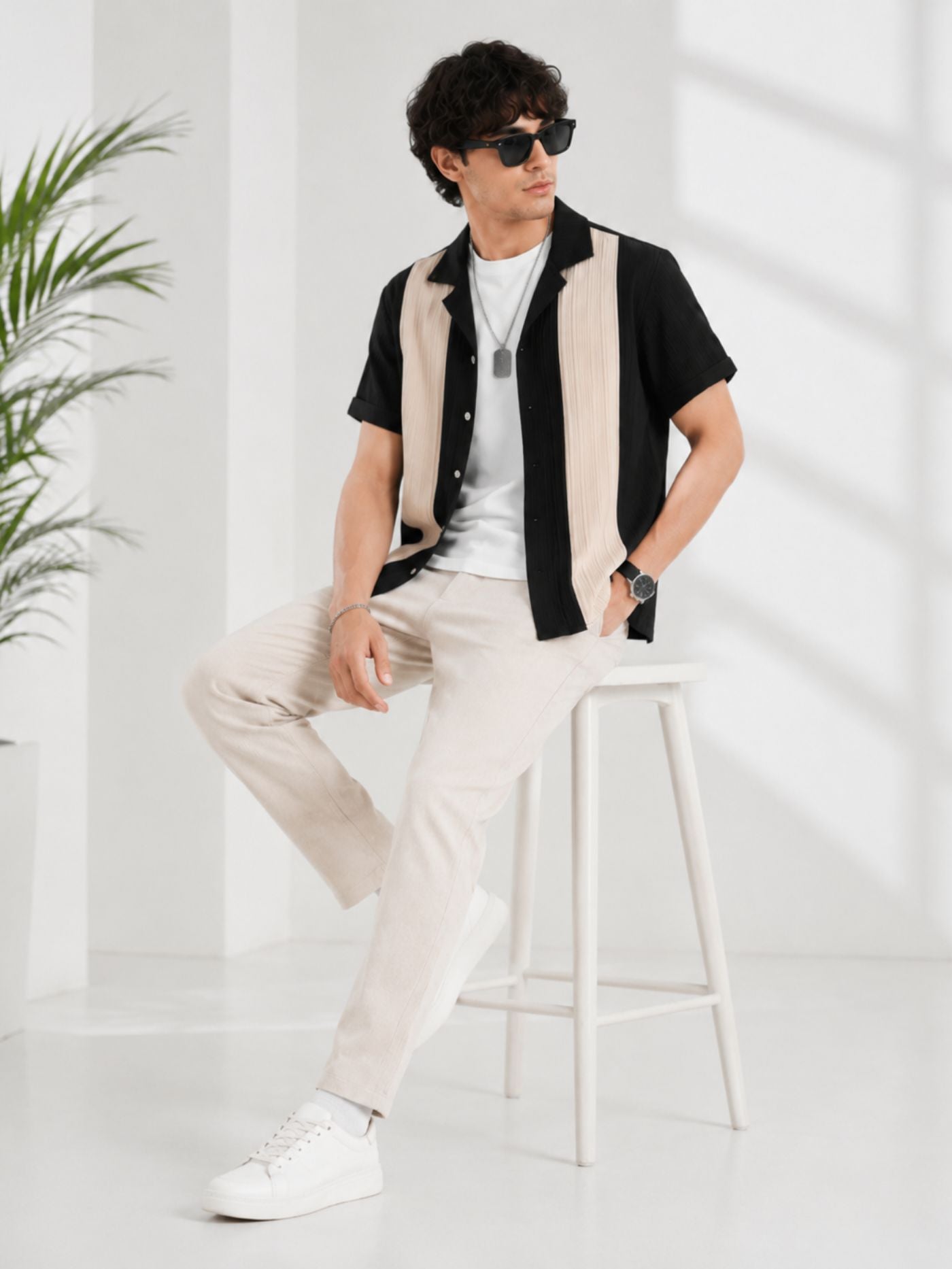 Black and Sand Half Sleeve Performance Shirt seated on stool