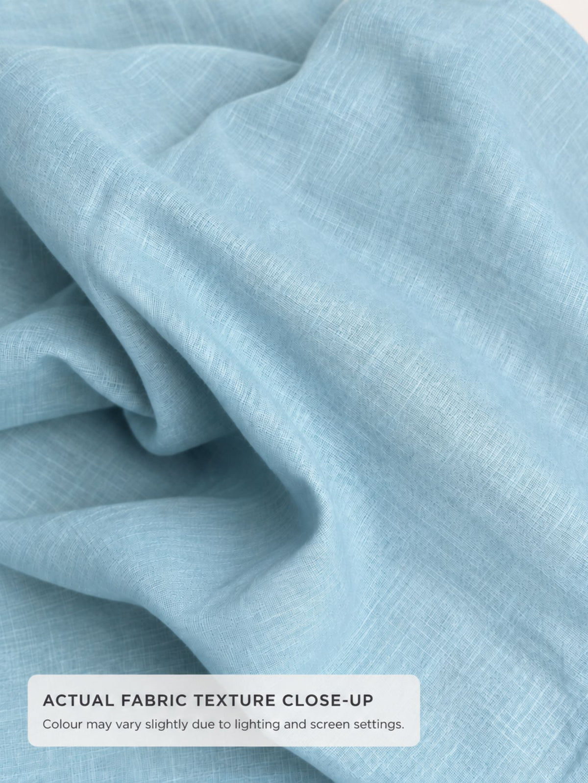 Close-up of seafoam blue pure cotton fabric showing fine woven texture and natural folds.