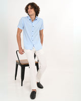 Full body view of man in Skyline Blue textured shirt with white pants.