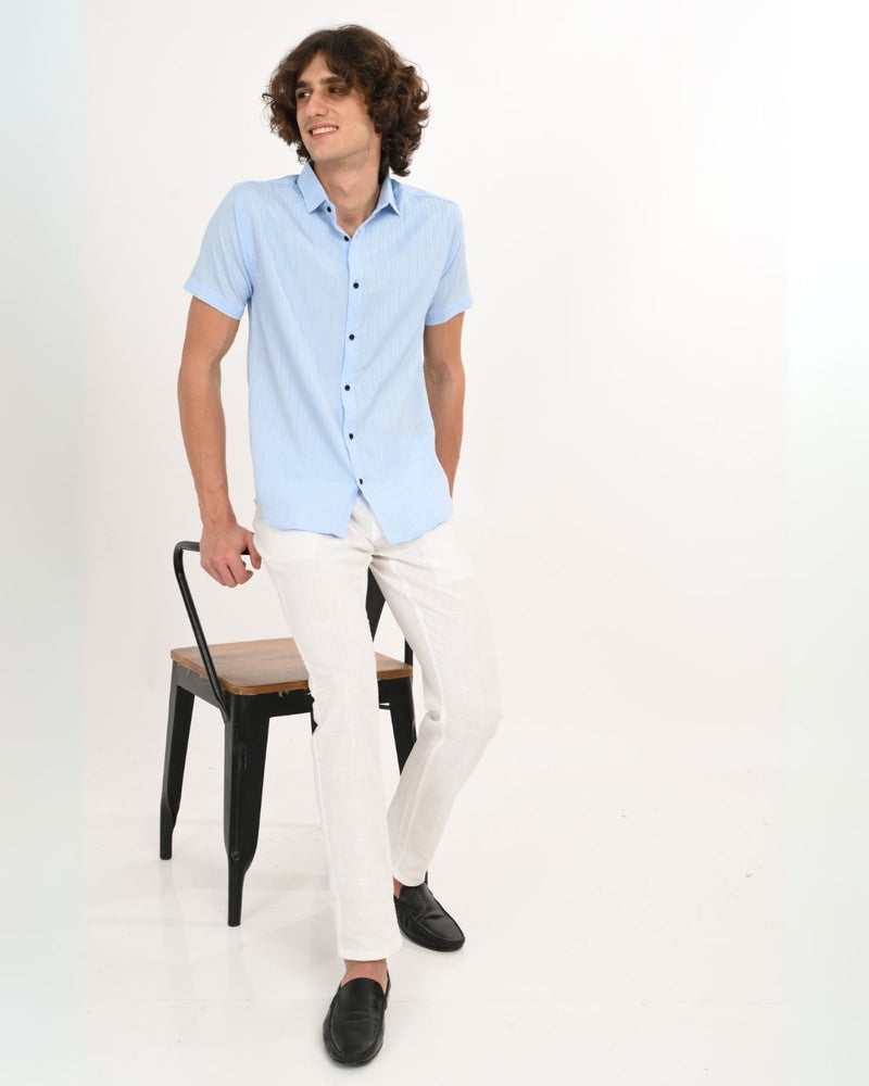 Full body view of man in Skyline Blue textured shirt with white pants.