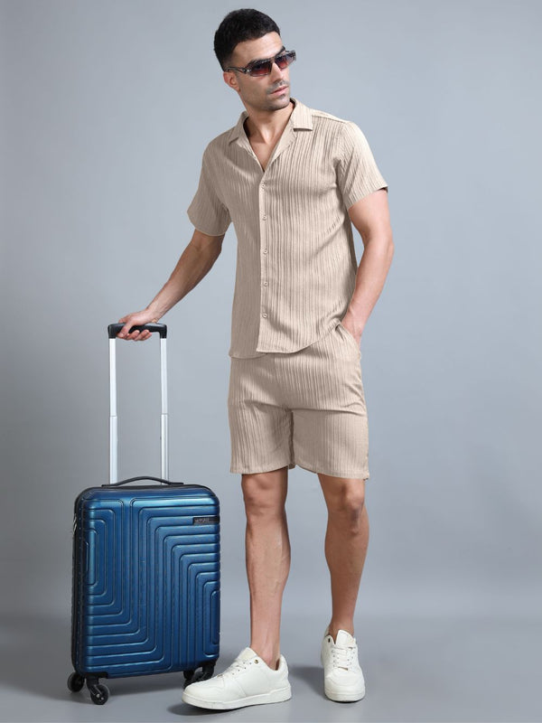 Man in Sahara Mist beige co-ord with suitcase