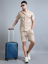 Man in Sahara Mist co-ord with suitcase