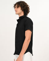 Man smiling in black textured button-down short-sleeve shirt