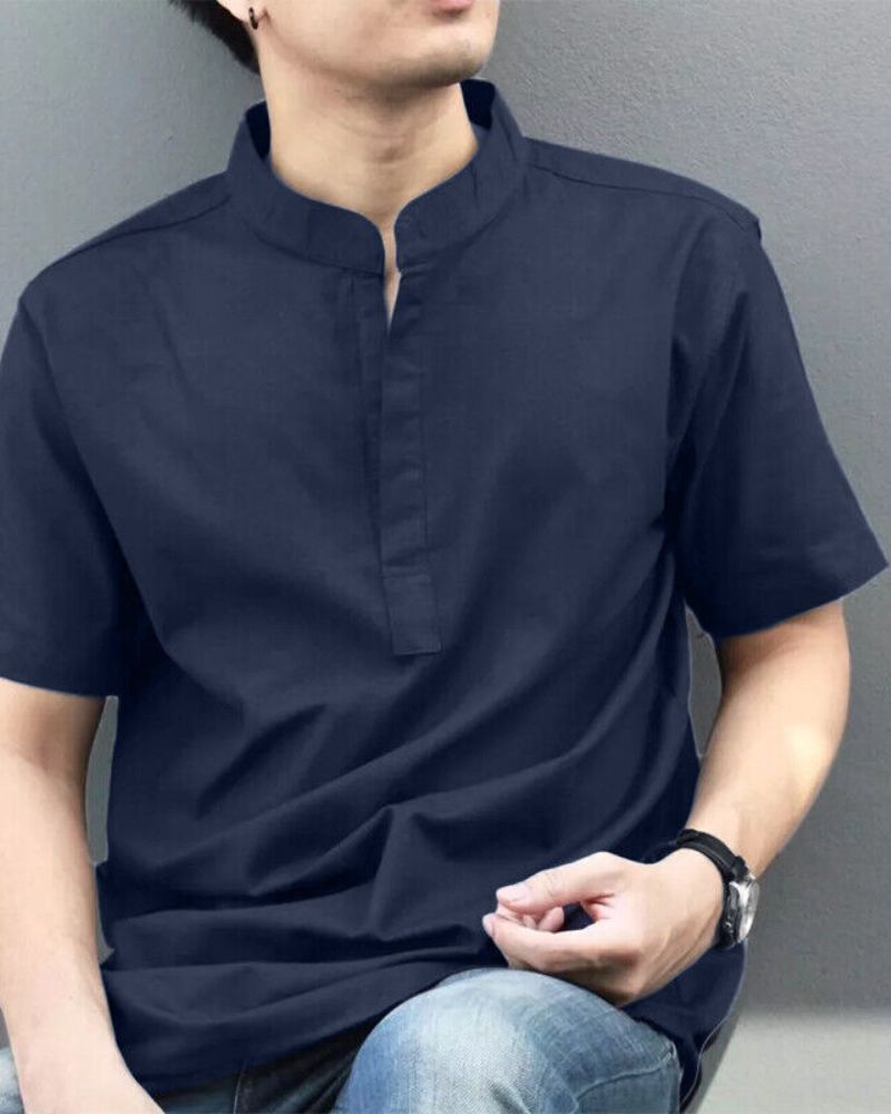 Men's navy blue short sleeve shirt with mandarin collar made from soft breathable magic cotton, styled casually with jeans

