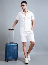 Men’s white co-ord set styled for casual summer look, seated pose