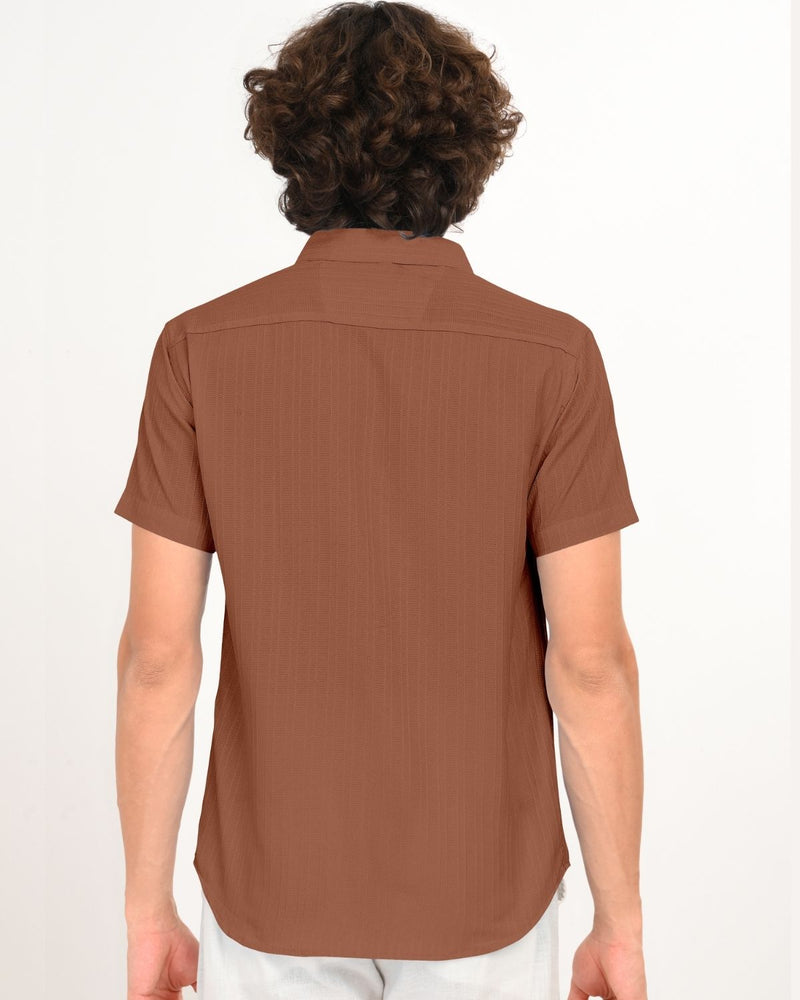 Model posing in rust brown short-sleeve textured shirt