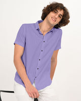 Model sitting wearing lavender textured short-sleeve shirt