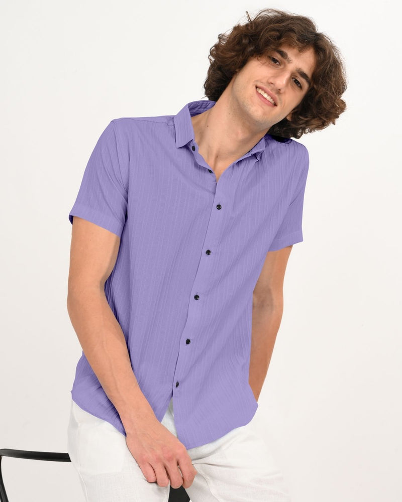 Model sitting wearing lavender textured short-sleeve shirt