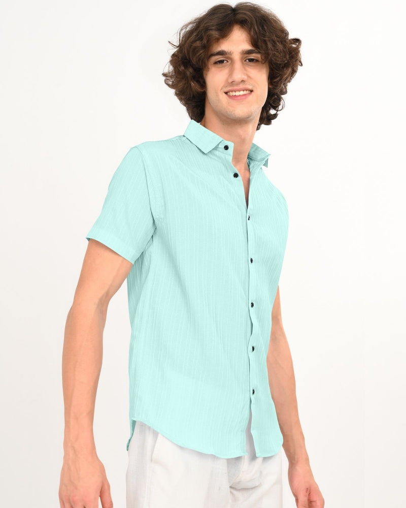 Side angle of model wearing mint green textured short-sleeve shirt
