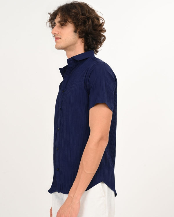 Side profile of model in navy blue textured short-sleeve shirt