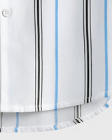 Close-up view of curved hem of men's white shirt with blue and black stripes and visible button placket

