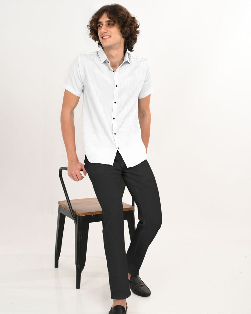 White textured shirt with black buttons styled with black pants